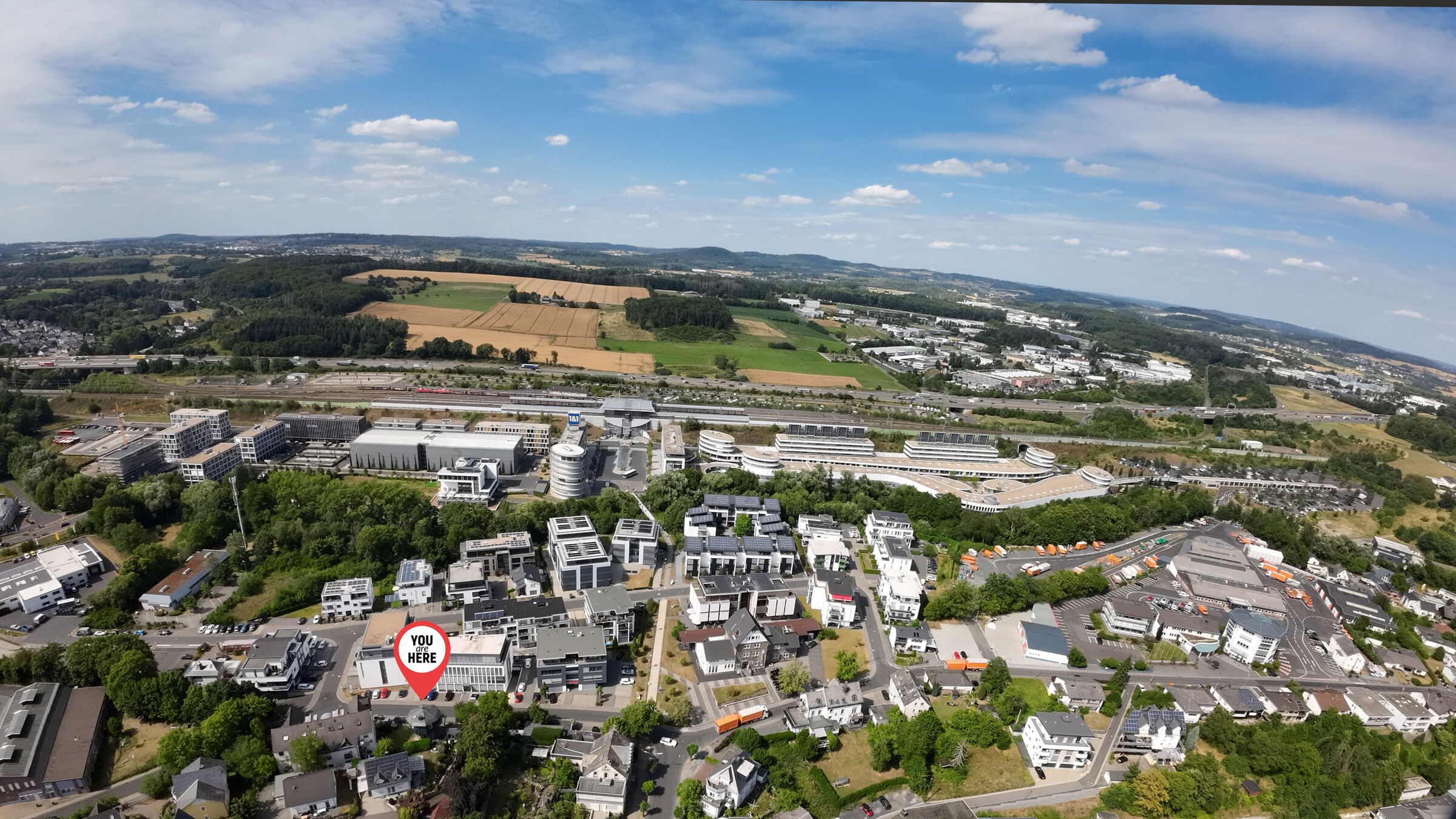 Luchtfoto van Montabaur met markering bij de watertoren, daarachter de ICE-lijn en het Westerwald